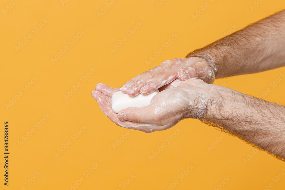 Close up cropped of male hold wash hand antibacterial antiseptic sanitizer soap foam isolated on yellow background. Epidemic pandemic hygiene coronavirus 2019-ncov covid-19 flu virus Mockup copy space Close up cropped of male hold wash hand antibacterial antiseptic sanitizer soap foam isolated on yellow background. Epidemic pandemic hygiene coronavirus 2019-ncov covid-19 flu virus Mockup copy space