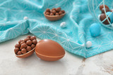 Tasty chocolate Easter eggs with candies on table
