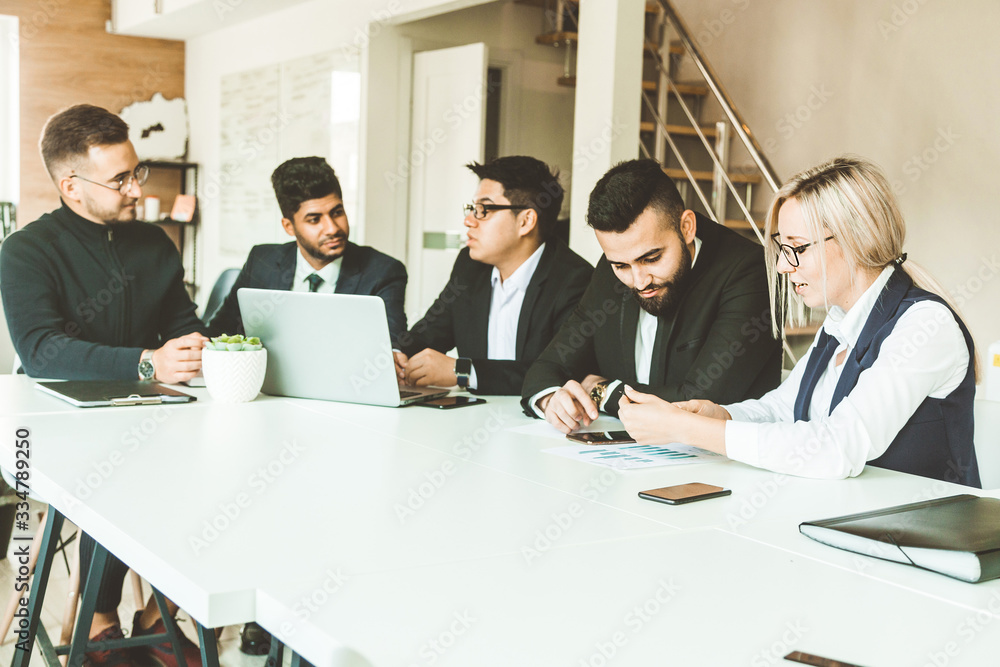 A team of young businessmen working and communicating together in an office. Corporate businessteam and manager in a meeting. A team of young businessmen working and communicating together in an office. Corporate businessteam and manager in a meeting.