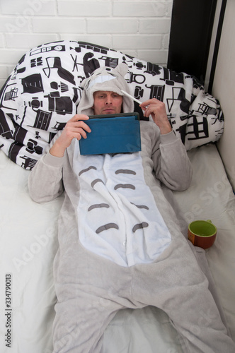 Man in a funny pajamas with a digital tablet. Working from home. 
