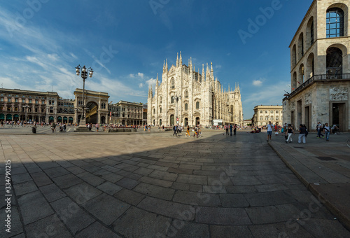 MILAN, ITALY - AUGUST 1, 2019 : The piazza, looking roughly north-east to the Duomo - on the right, and the arch that marks the entrance to Galleria Vittorio Emanuele II - on the left