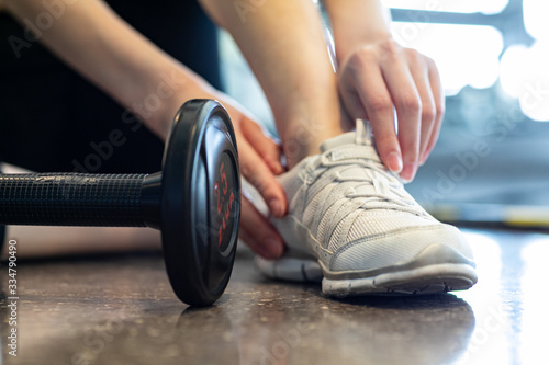 Women are using their hands to tie their shoes, have a dumbbell lifestyle and healthy concept.