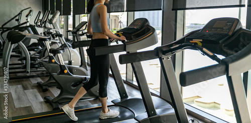 Legs of woman running on a treadmill in gym