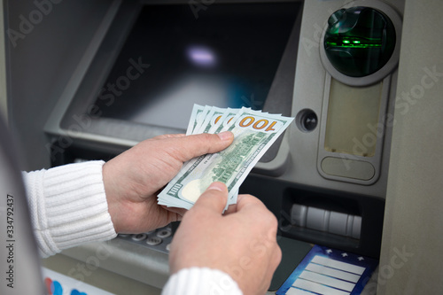 male hands hold money dollars received from an ATM
