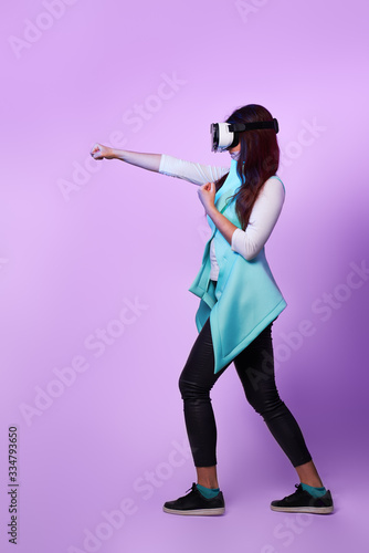 Woman is using virtual reality headset, playing game and fighting.