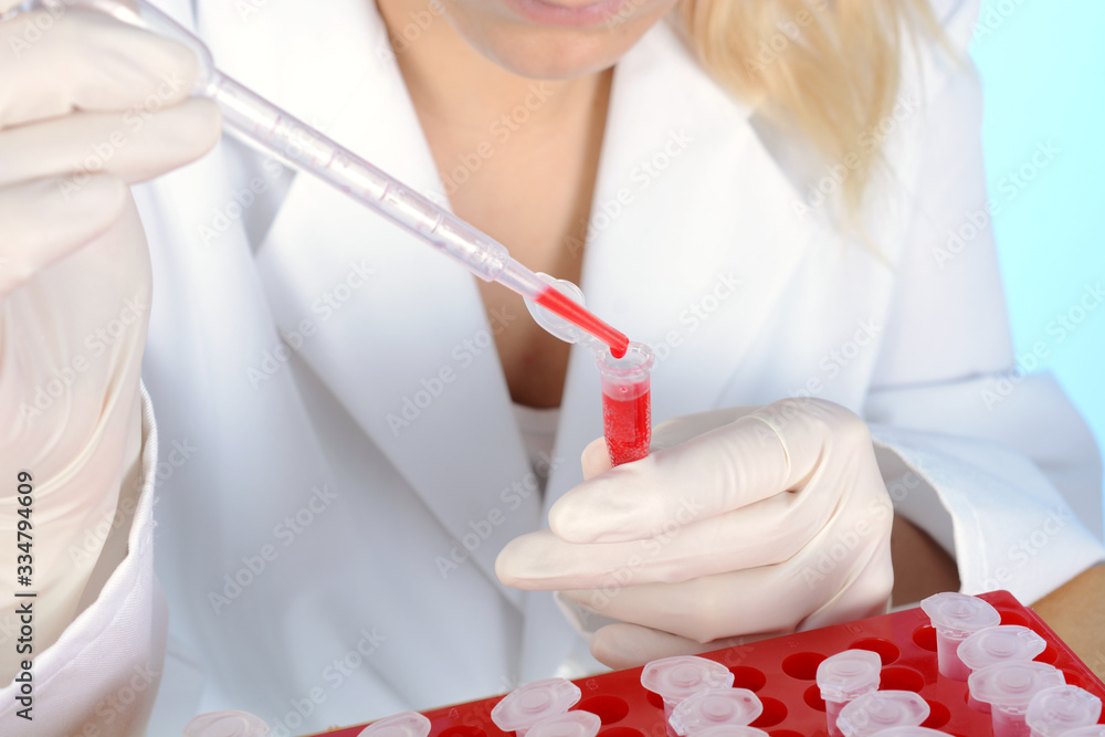 Scientist or doctor with reaction tube and pipette during examination and evaluation of sample Scientist or doctor with reaction tube and pipette during examination and evaluation of sample
