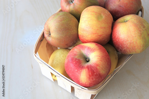 Basket of fresh apples on wood table 