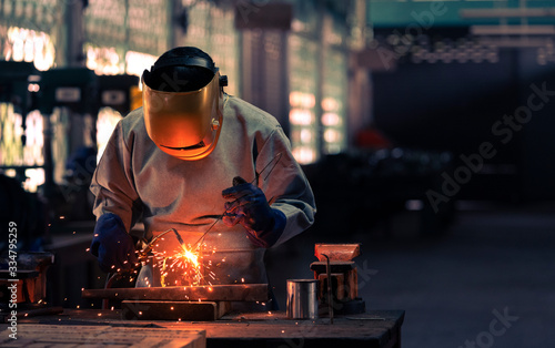 Industrial professional welder is welding metal part in the factory. skill and technician concept.