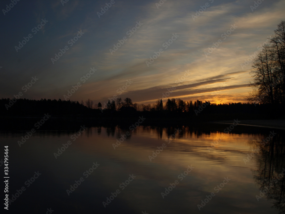 Obraz premium pink and purple pre dawn sunrise with mirrored reflections in lake