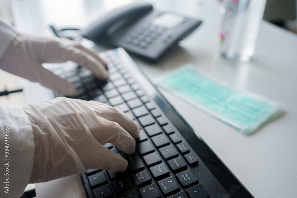 Close up on hands in medical gloves typing on keyboard. Protective care. Emergency problem. Healthcare employee practitioner, distance working and learning concept. Modern technology background. Close up on hands in medical gloves typing on keyboard. Protective care. Emergency problem. Healthcare employee practitioner, distance working and learning concept. Modern technology background.