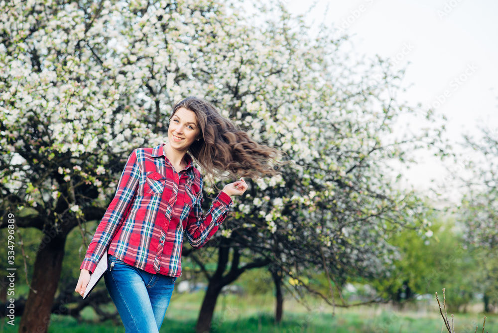 Attractive woman with tablet in blooming garden Attractive woman with tablet in blooming garden