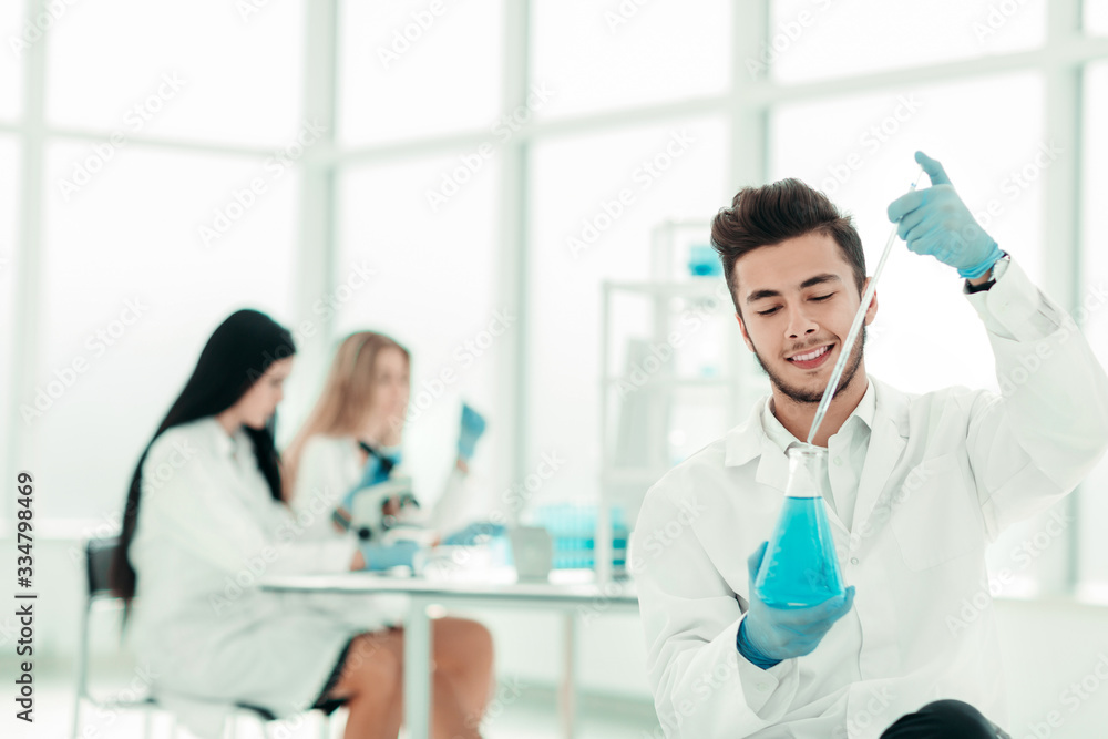 close up. man scientist holding a flask of blue liquid close up. man scientist holding a flask of blue liquid