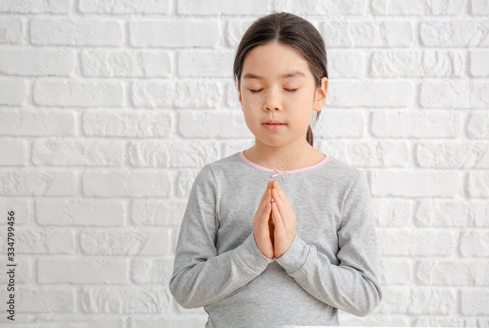 Cute little Asian girl praying on white background Cute little Asian girl praying on white background