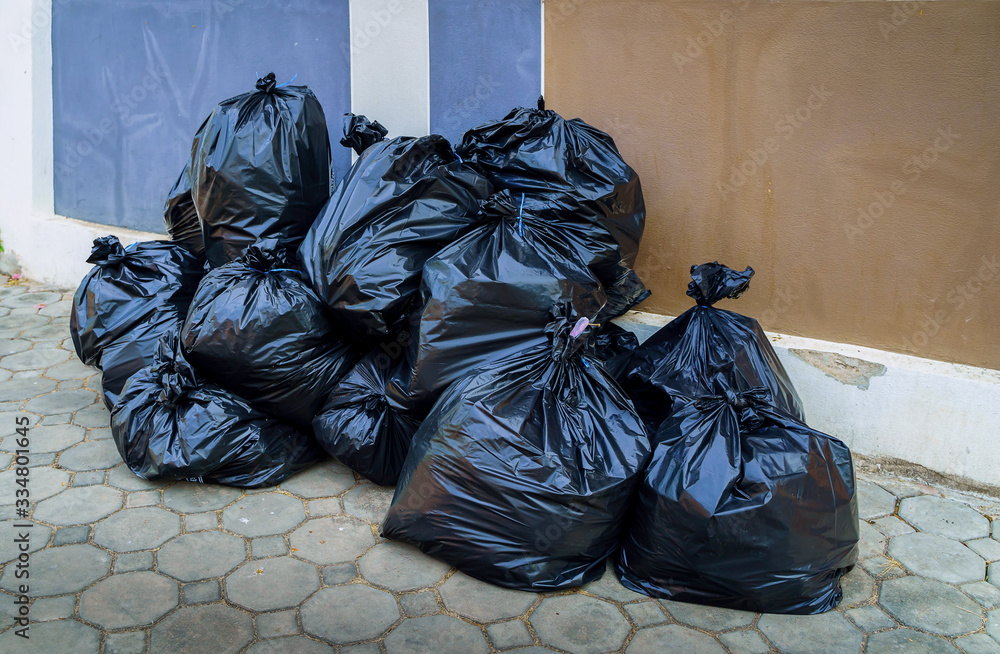 Pile of Garbage plastic black and trash bag waste many stacked on a sidewalk in big city, Pollution trash and Plastic Waste many on floor, Waste plastic. Pile of Garbage plastic black and trash bag waste many stacked on a sidewalk in big city, Pollution trash and Plastic Waste many on floor, Waste plastic.