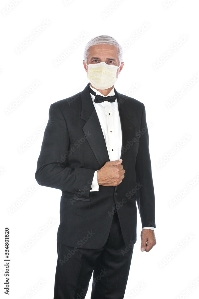 Mature Adult Male Wearing Tuxedo and Covid-19 protective mask, holding lapel and one hand at side, isolated on white. Mature Adult Male Wearing Tuxedo and Covid-19 protective mask, holding lapel and one hand at side, isolated on white.
