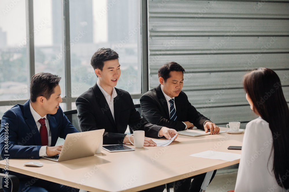 Woman during job interview and four elegant members of management