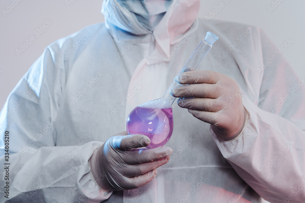 Glass medical burette in a doctor's hand. A burette with a cure holds a