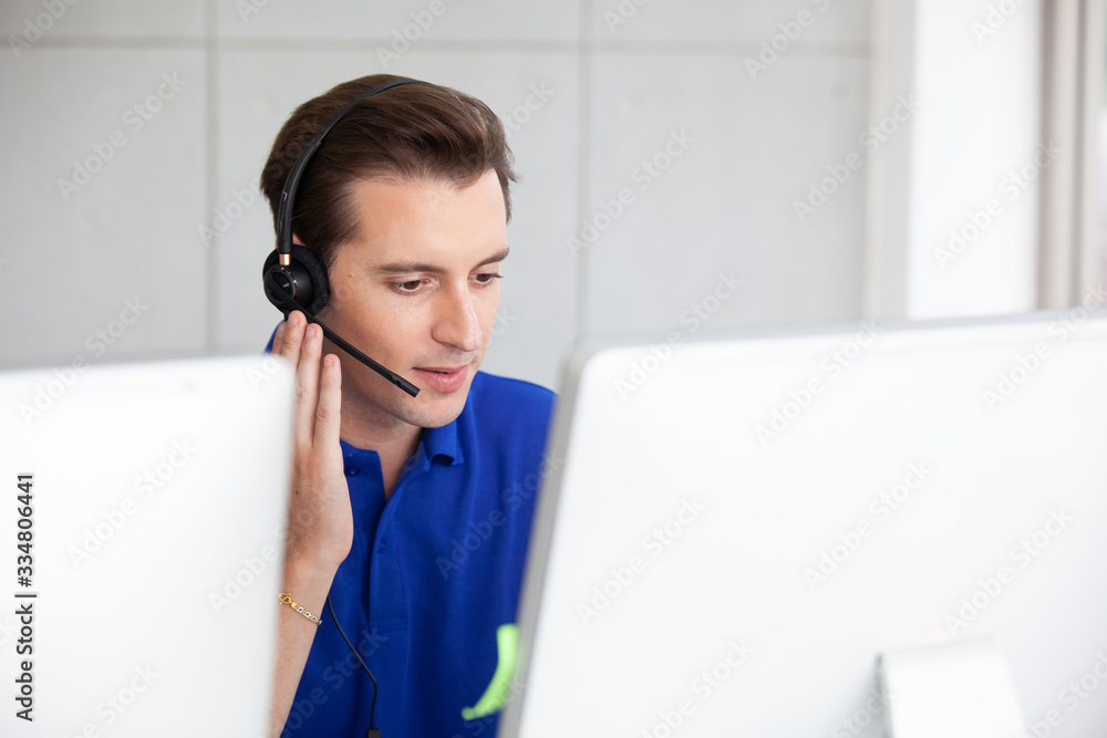 Young handsome male customer support phone operator with headset working in call center. Young handsome male customer support phone operator with headset working in call center.