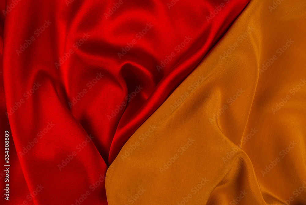 Red and orange silk or satin luxury fabric texture can use as abstract background. Red and orange silk or satin luxury fabric texture can use as abstract background.