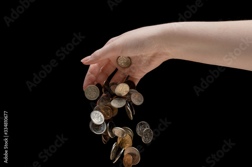 ruble coins fall from the hand down on a black background, the concept of the ruble's depreciation, economic crisis, recession and impoverishment