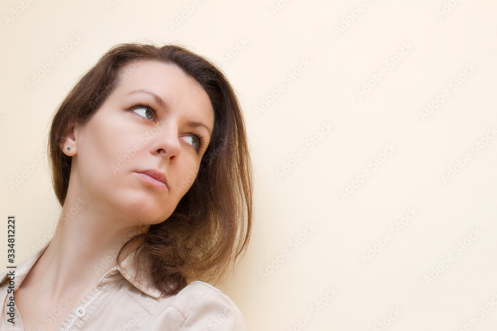 Brunette offended without strong makeup on a beige background Brunette offended without strong makeup on a beige background