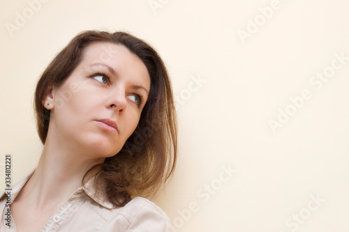 Brunette offended without strong makeup on a beige background