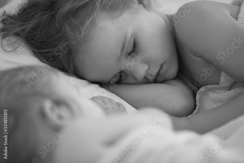 sister sleep together in bed home