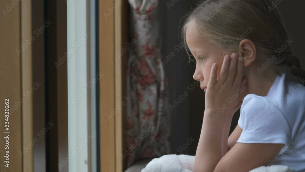 Stay at home quarantine coronavirus pandemic prevention, girl looking out of the window without being able to go out for a walk Stay at home quarantine coronavirus pandemic prevention, girl looking out of the window without being able to go out for a walk