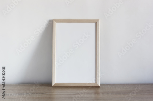 empty white frame on a wooden table.