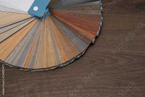A palette of textures and decor for the wooden floor of the laminate and vinyl on a dark wooden background. Interior Design. Planning and building a house. Copy space.