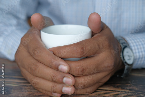 close up of man hand holding coffee mug.