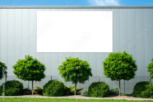 Blank white billboard for advertisement mounted on the wall of warehouse/factory