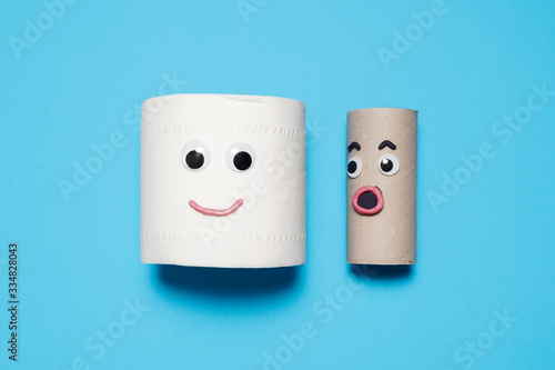 Happy smiling full toilet paper roll next to a surprised empty toilet roll with googly eyes and mouths on a blue background