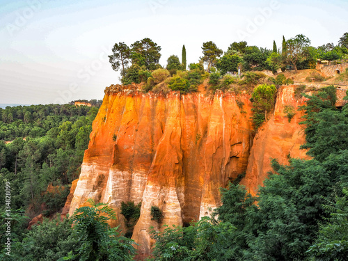Sunlight reflects off Ochre cliff of Roussillon, France, just before sunset.