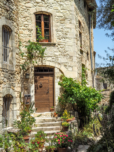Medieval windows arches and doors in Provence, surrounded by greenery. © Kathryn