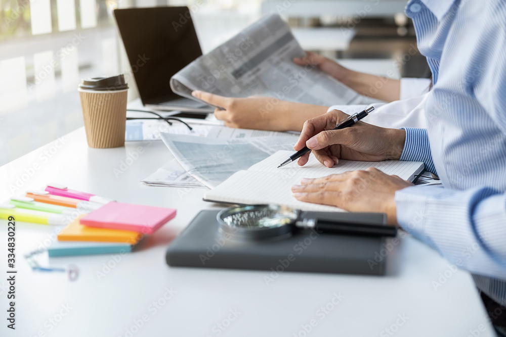 Young unemployed is searching for a job in the newspaper and laptop. Interview the job and hiring concept. Young unemployed is searching for a job in the newspaper and laptop. Interview the job and hiring concept.