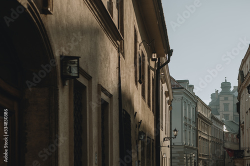 The game of the afternoon sunlight on the walls of old buildings in the historical center of Poland city of Krakow with enlightened street lamp in the background