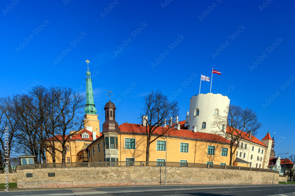 Funny cartoon style Riga Castle in spring sunny day with blue sky