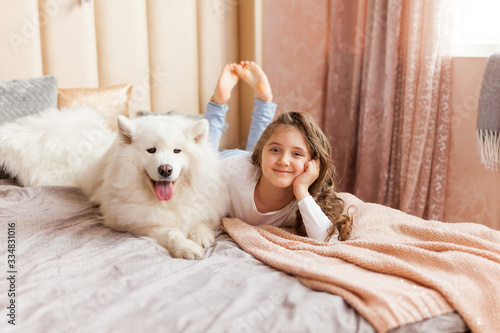 Home portrait of cute child hugging with dog on the sofa