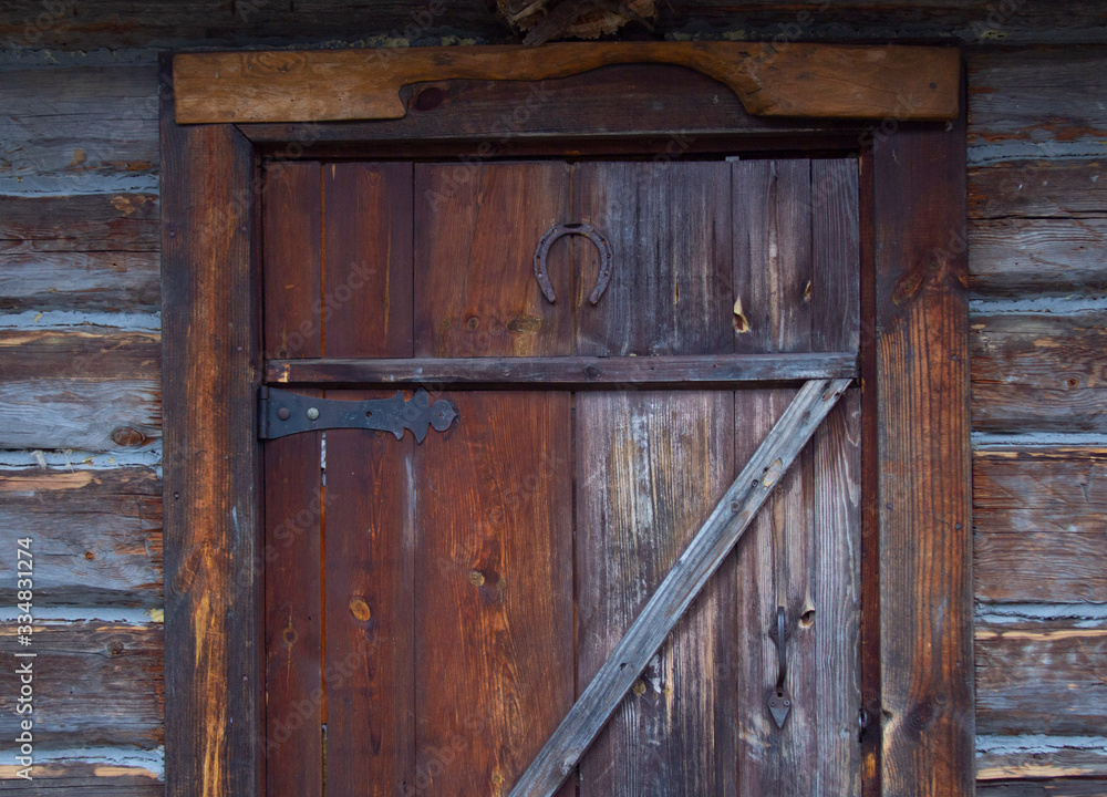 Wooden door of an old barn with metal hinges. Wooden door of an old barn with metal hinges.