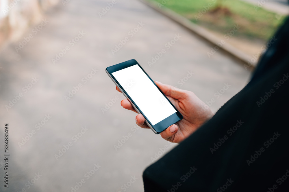 Mobile phone with blank screen in hand of young woman