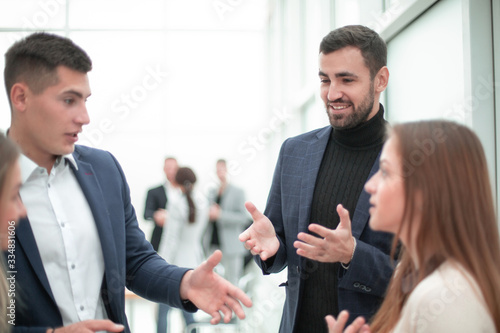 young employees discussing their ideas standing in the office