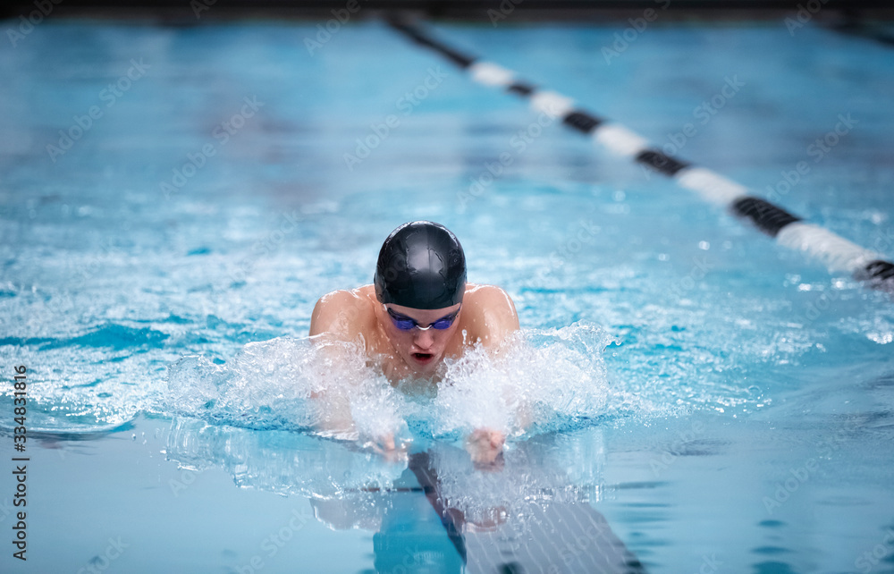 Young male swimmer swims the breaststroke in a competition - obrazy, fototapety, plakaty 