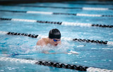Young male swimmer swims the breaststroke in a competition