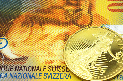 A macro image of a  yellow ten Swiss franc note with a gold coin.  Shot close up. photo