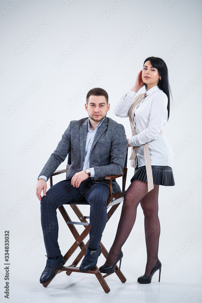 Obraz premium Successful man in a suit and a woman future businessmen are smiling and talking about a new project. Business partners stand on a white background.