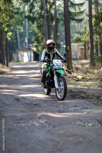 Fototapeta Naklejka Na Ścianę i Meble -  off-road motorcycle trip in the forest, beautiful girl, feminism, sport, brutality, motorcyclist equipment, motorcycle driver, concept, active lifestyle, enduro