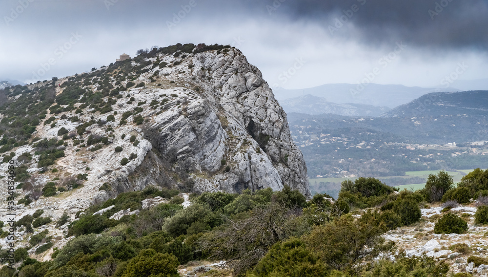 The mountain over grotto of Mary Magdalene at cloudy weather, clouds over a valley, a dry grass