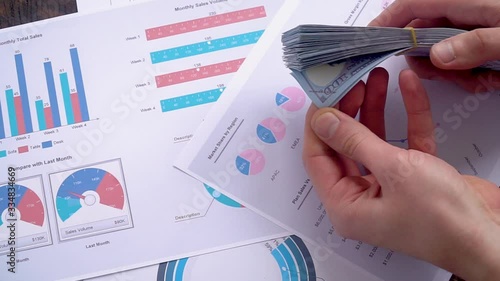 Men's hands recalculate a pack of hundred-dollar bills