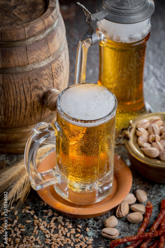 Light frothing beer in a glass, on an old background.